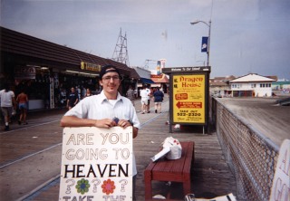 man holding sign on boardwalk